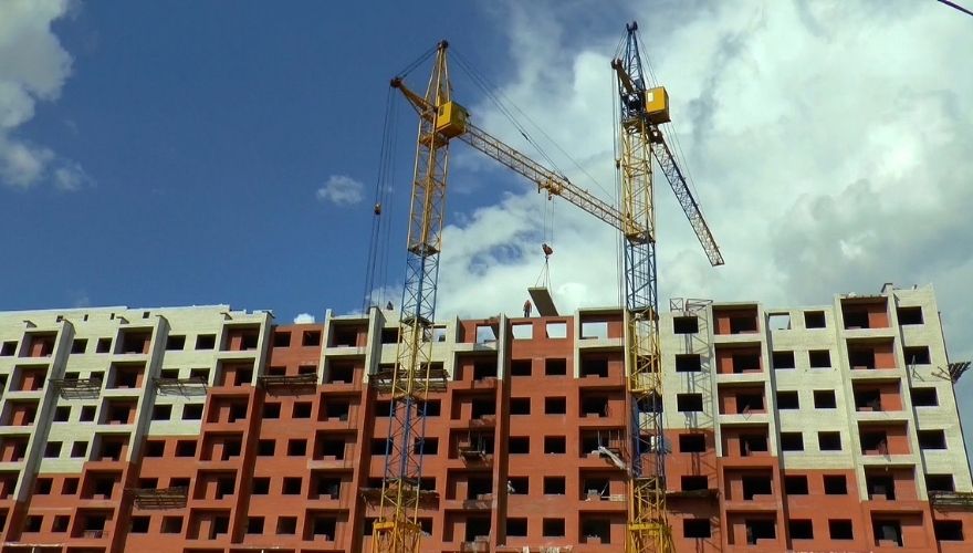 Apartment buildings under construction with cranes for subsidized housing development.